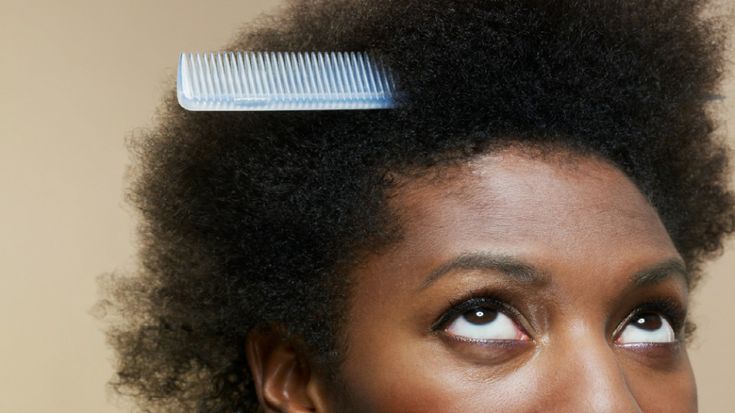 Detangling your hair with wide-tooth comb to reduce breakage